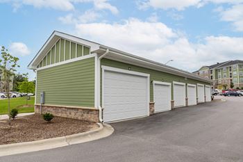 A green building with a white garage door.